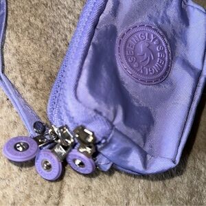 BN Seeingly purple coin/small bag with its 3 zip compartments and a small strap.